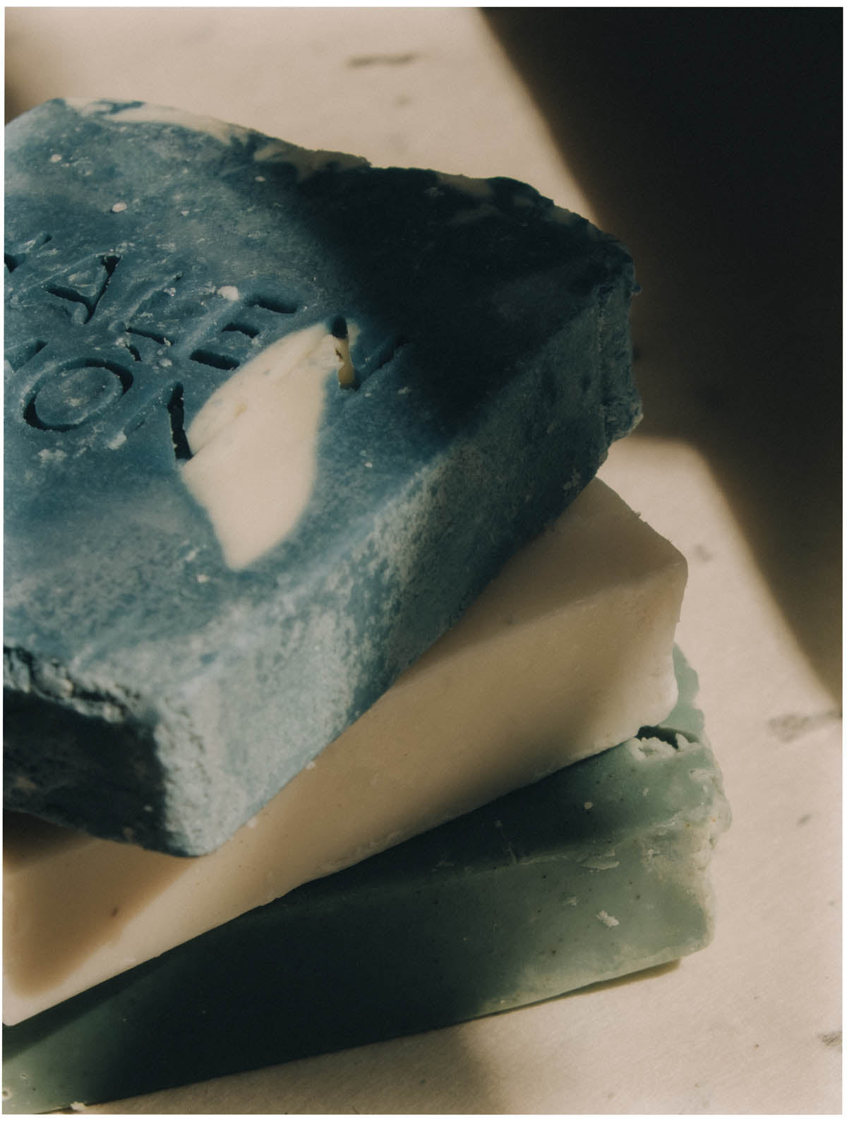 A stack of cold-process soaps in sea-glass colours